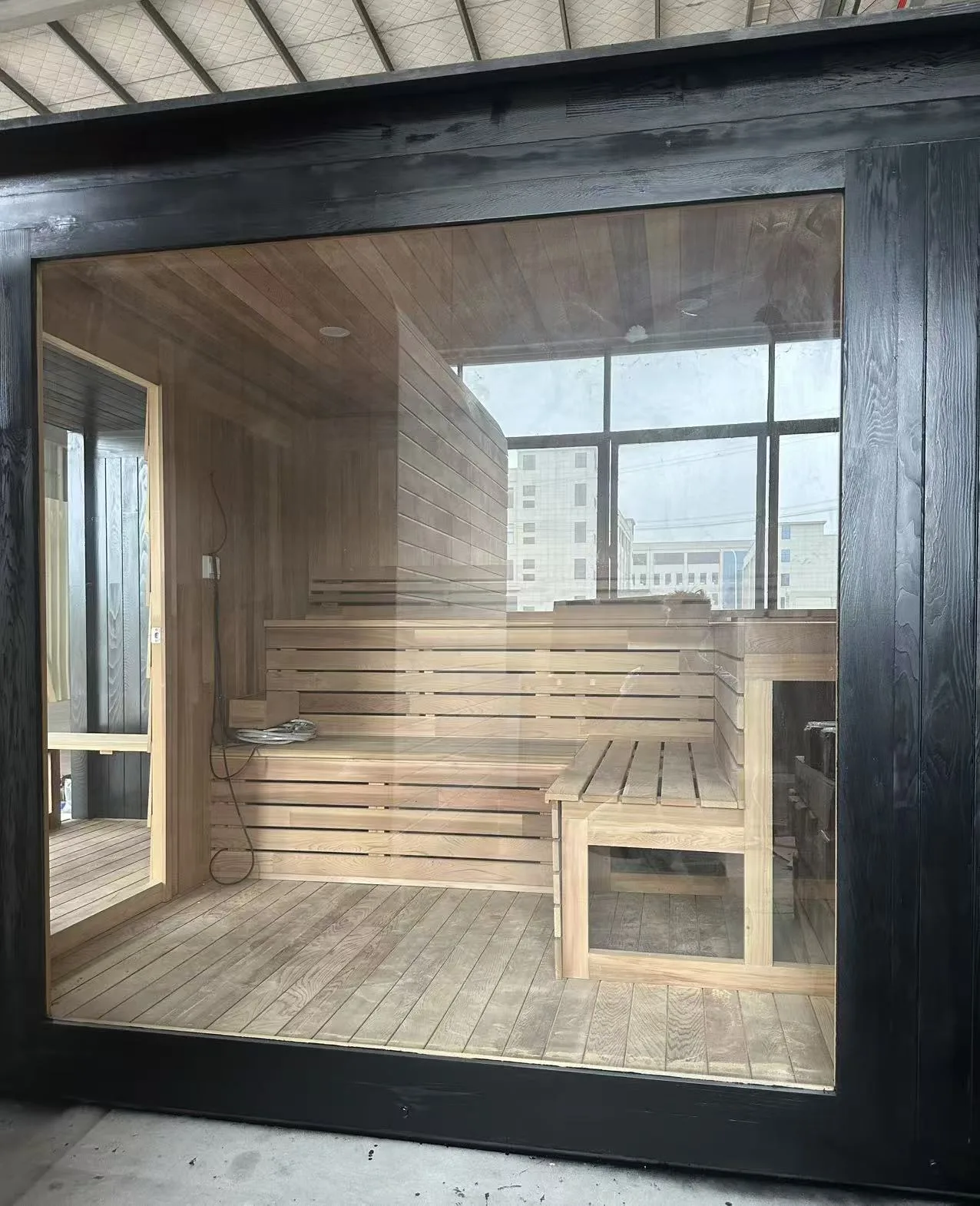 Glass-fronted outdoor sauna cabin at the production facility
